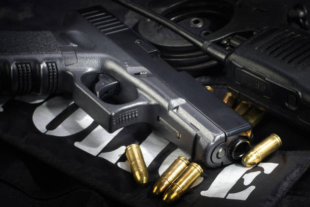 istock Police weapon and equipment on black uniform background 912599842