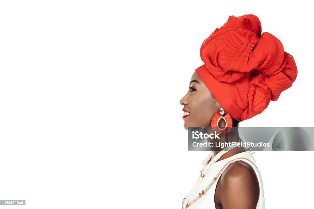 vista laterale della donna afroamericana in accessori etnici isolati su bianco - Foto stock royalty-free di Popolo di discendenza africana