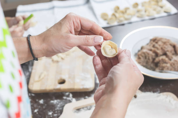 istock Female hands hold freshly dumplings on the background of kitchen workspace 912607948