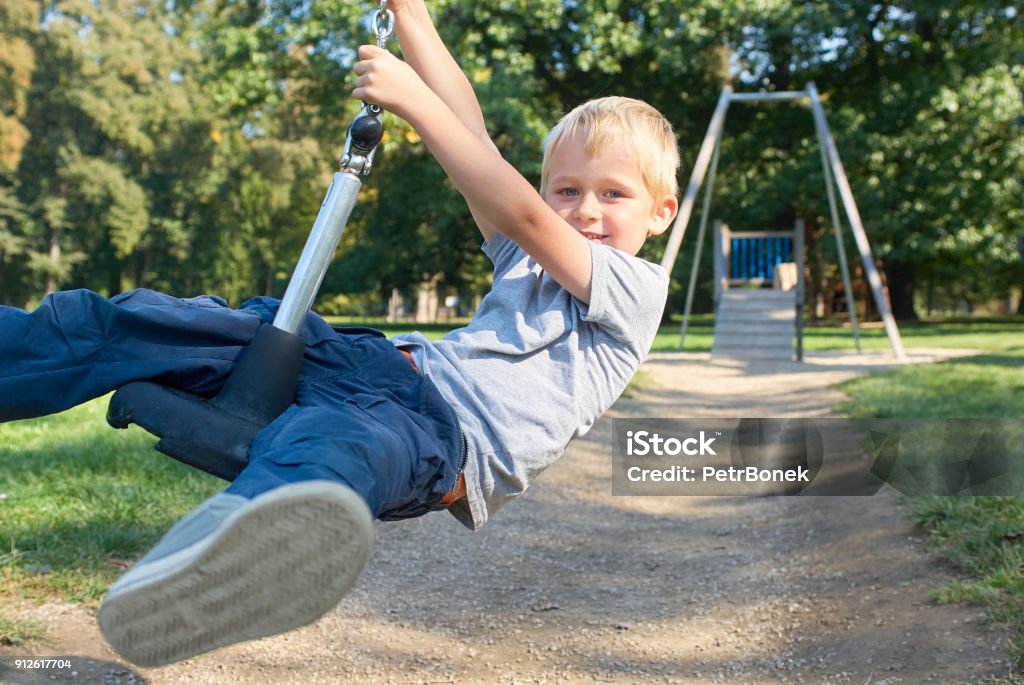 Child boy rides on Flying Fox play equipment Child boy rides on Flying Fox play equipment in a children's playground, summertime Active Lifestyle Stock Photo