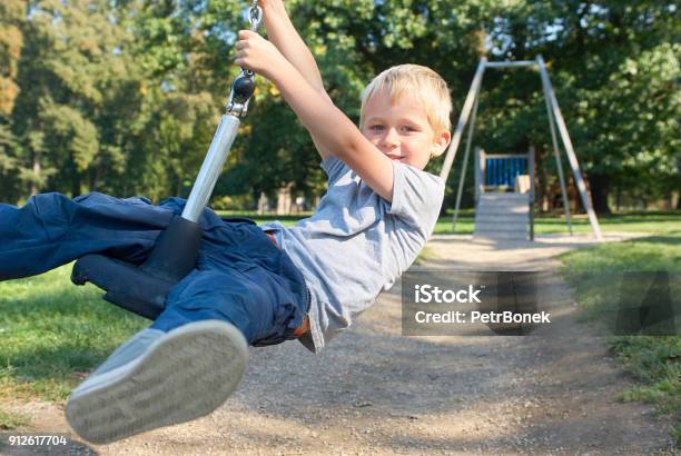 Child Boy Rides On Flying Fox Play Equipment Stock Photo - Download Image Now - Active Lifestyle, Activity, Adventure