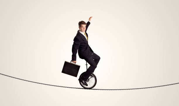 istock Extreme business man riding unicycle on a rope 912625092