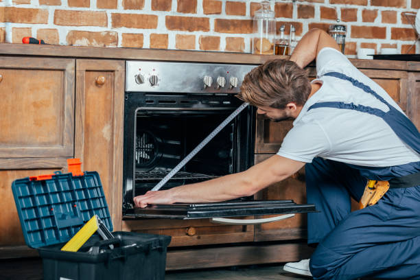 istock young foreman in protective workwear measuring oven with tape 912625410