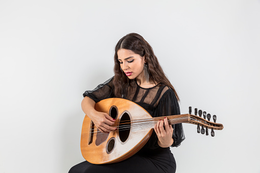 Oud playing women. Young woman playing lute string instrument
