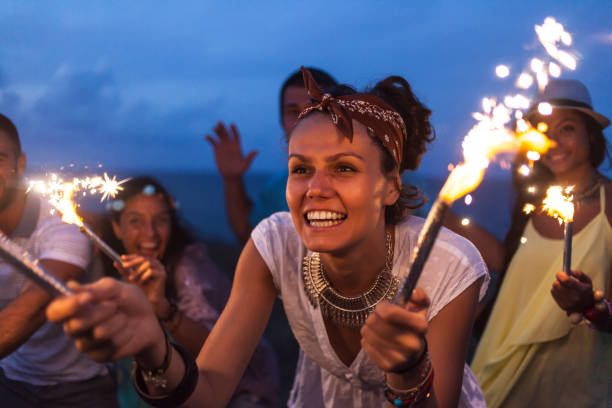 istock Woman celebrating with fireworks on beach at night 912633162
