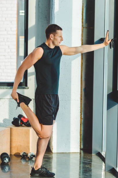 istock side view of young man stretching before workout in gym 912634312