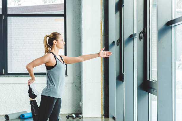istock side view of sportswoman warming up before workout in gym 912641554