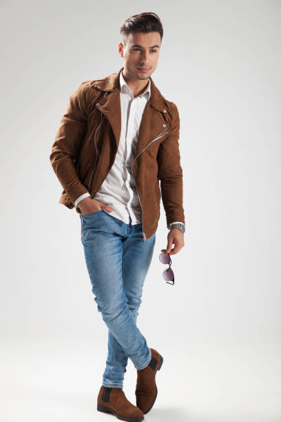 istock smiling casual man holding sunglasses and standing 912644170