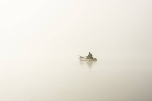 istock fisherman in boat in fog 912644406