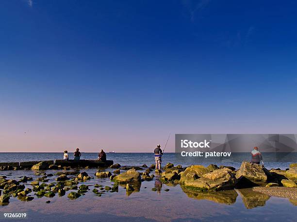 Gruppo Di Pescatori Sulla Costa - Fotografie stock e altre immagini di Acqua - Acqua, Alba - Crepuscolo, Ambientazione esterna