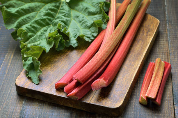 Fresh rhubarb Fresh rhubarb on wooden board rhubarb photos stock pictures, royalty-free photos & images