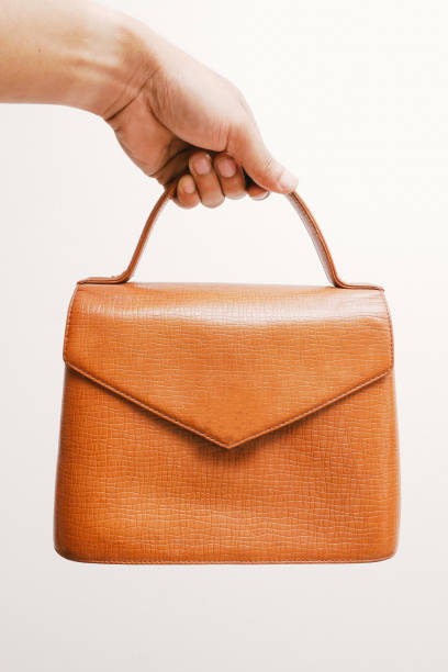 istock woman hand holding vintage suitcase on white background. 912658726