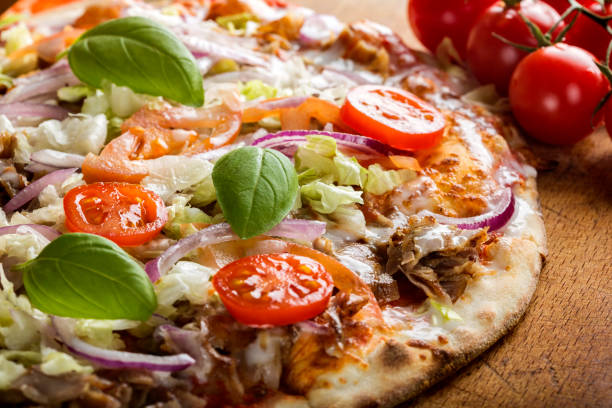Kebap pizza made with minced meat, cabbage, tomato and garlic sauce stock photo