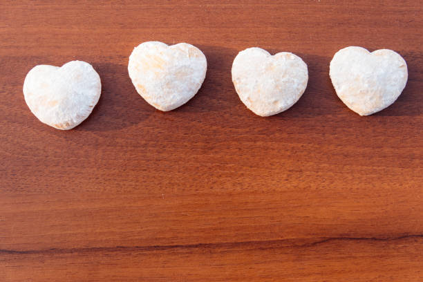 istock Heart shaped cookies covered with powdered sugar on wooden table 912663726