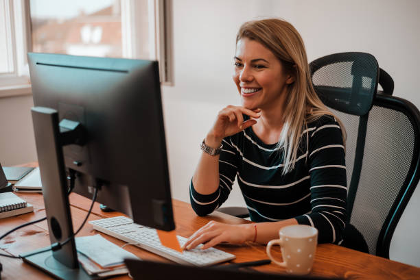 sonriente mujer de negocios rubio trabaja en escritorio de oficina. - adminstrator fotografías e imágenes de stock