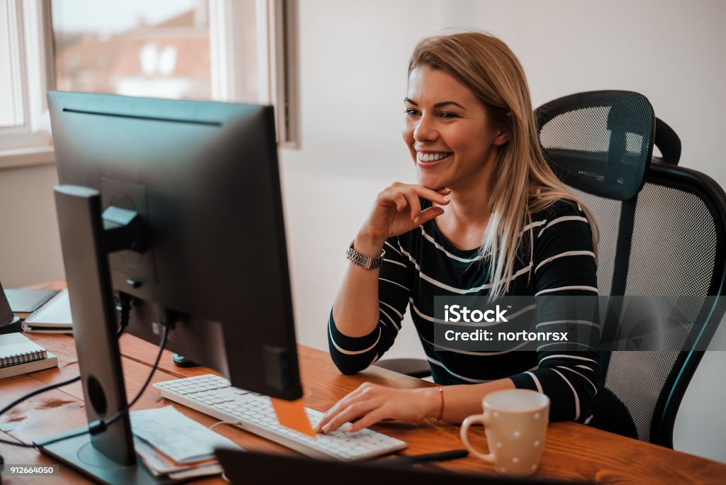 Smiling blonde business woman working at office desk. Administrator Stock Photo