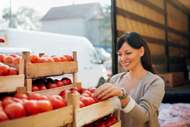 istock Young happy attractive woman choosing tomatoes. 912664220