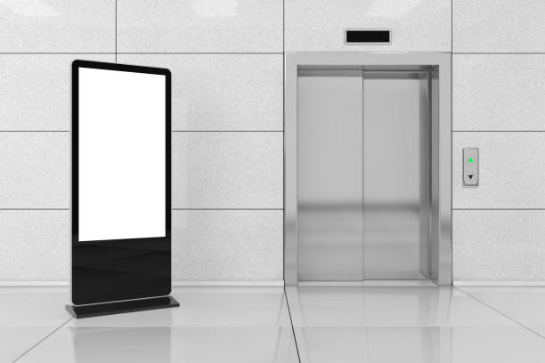 istock Blank Trade Show LCD Screen Stand as Template for Your Design near Modern Elevator or Lift with Metal Doors in Office Building. 3d Rendering 912665062
