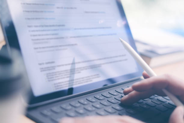 istock Blogger using mobile touchpad and stylus pen for work.Male hands typing electronic tablet keyboard-dock station.Horizontal, blurred background. 912665150