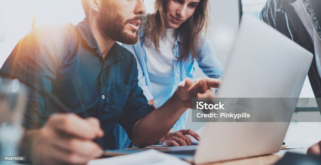 Grupo de colegas de trabalho sentado na mesa de madeira e trabalhando juntos em novo projeto de inicialização no escritório sotão moderno. Horizontal.Blurred fundo. Cortadas. - Foto de stock de Tecnologia royalty-free