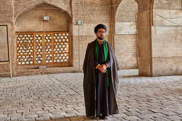 Iranian mullah stands in courtyard of mosque, Isfahan, Iran. Isfahan, Iran - April 24, 2017: Iranian mullah in traditional clothes stands in the courtyard of the mosque. mullah photos stock pictures, royalty-free photos & images