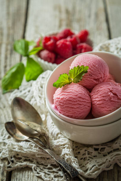 istock Raspberry ice cream in white bowl, rustic wood background 912688484