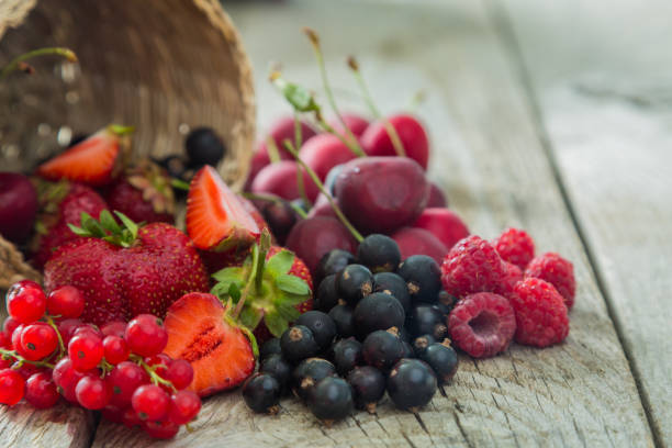 istock Selection of colorful berries on rustic background 912689584