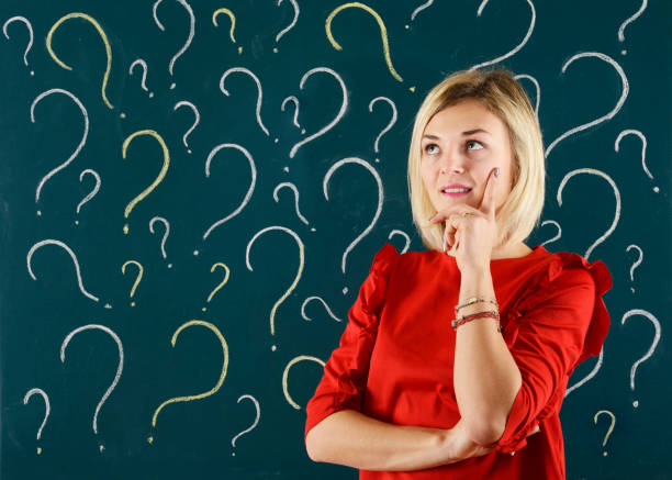 istock Pensive Woman in front of blackboard with question mark 912693078
