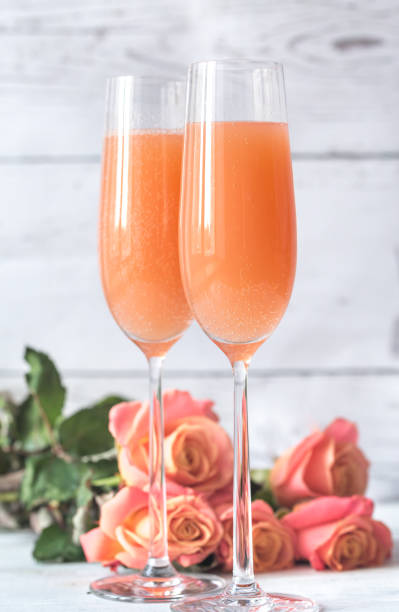 dois copos de cocktail bellini com buquê de rosas - champagne pink bubble valentines day - fotografias e filmes do acervo