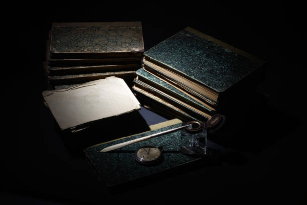 istock old books, papers, ink pen and inkpot on black background 912702872