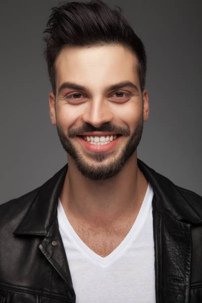 istock handsome young man in leather jacket is laughing 912705170