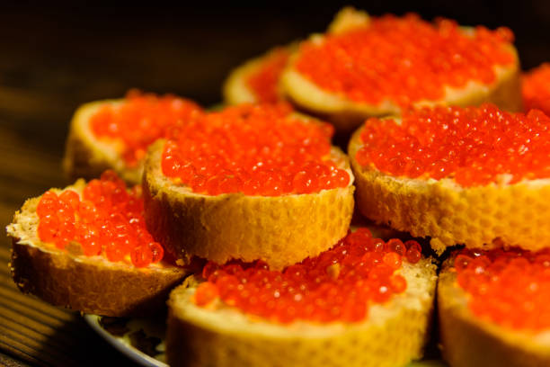 istock Sandwiches with red caviar on wooden table 912708546