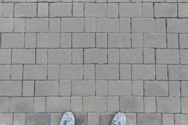istock Gray brick blocks with man feet 912712598
