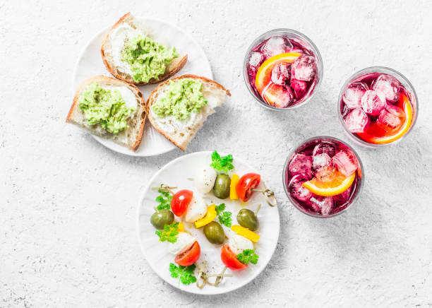 aperitiv table - select and snack on a light background, top view. sandwiches with avocado, canape with mozzarella, tomatoes, olives and spritz - mozzarella tomato sandwich picnic imagens e fotografias de stock