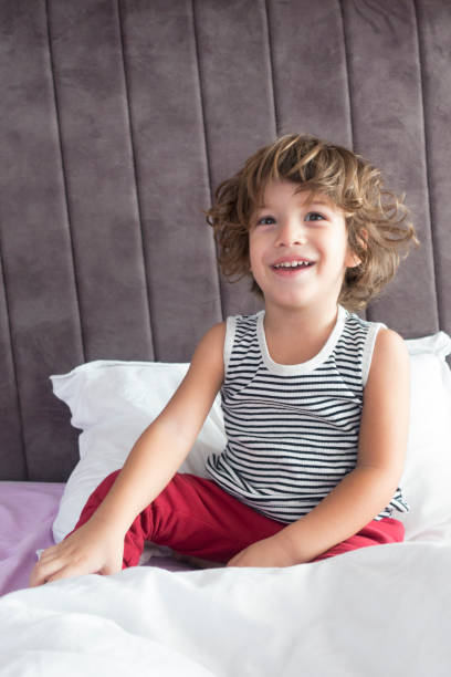 istock Little boy playing with joy on parents bed. 912720382
