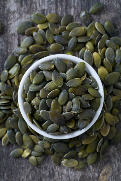 istock pumpkin seeds on wooden surface 912720396