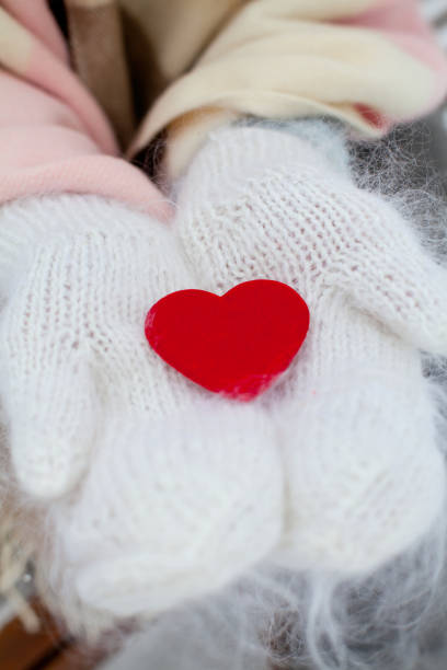 istock red heart in warm gloves 912723258