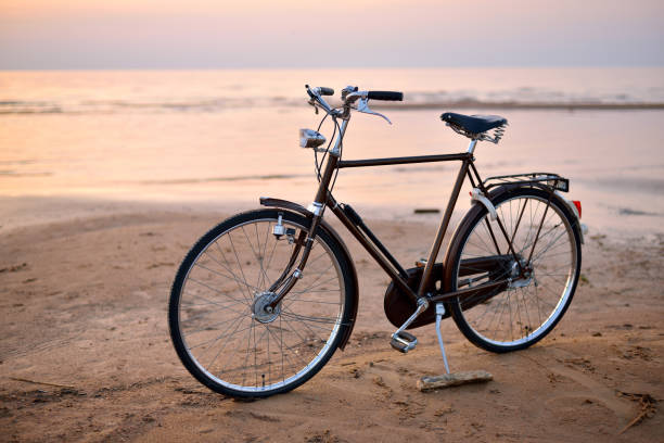 istock Sunset on the beach and a black bicycle. 912726460