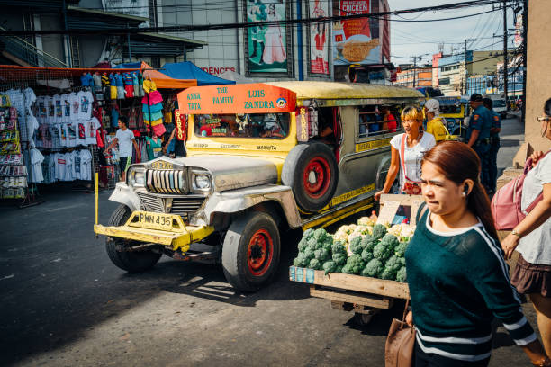 Manila, Philippines - December 26, 2025:A vibrant, chrome-plated Philippine jeepney, a traditional public transport, drives through a bustling street in Manila's Divisoria district, capturing local
