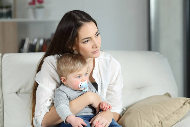 Sad woman looking away with her baby