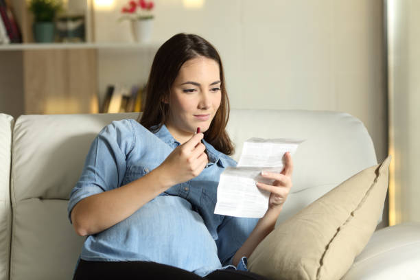 беременная женщина читает листовку, прежде чем принимать таблетки - vitamin pill capsule equipment data стоковые фото и изображения