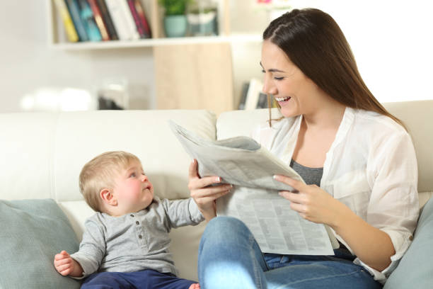 ребенок требует внимания своей матери - newspaper reading mother women стоковые фото и изображения