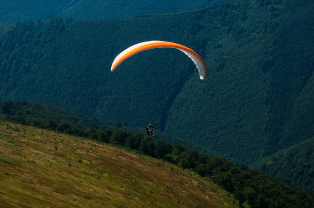 istock Paraglider flies over a mountain valley on a sunny summer day. 912747916