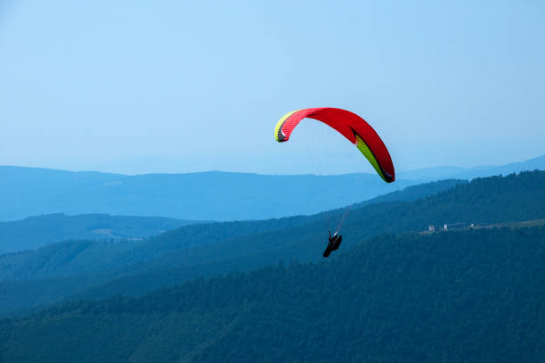 istock Paraglider flies over a mountain valley on a sunny summer day. 912747928
