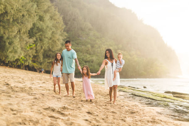 istock Family Walking Along Hawaii Beach Together 912748220