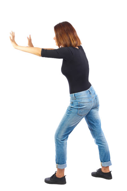 istock back view of woman pushes wall. 912750876