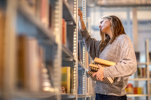 istock Beautiful female university student studying on campus library 912750920