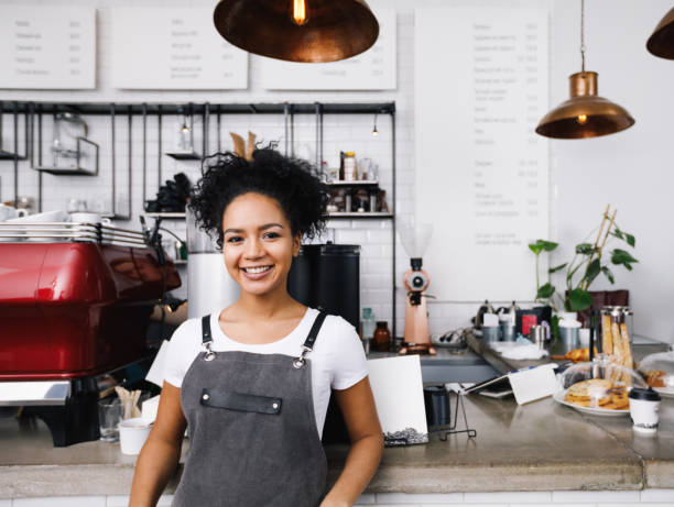 istock Young smiling barista wearing apron, standing at cafe counter 912751052