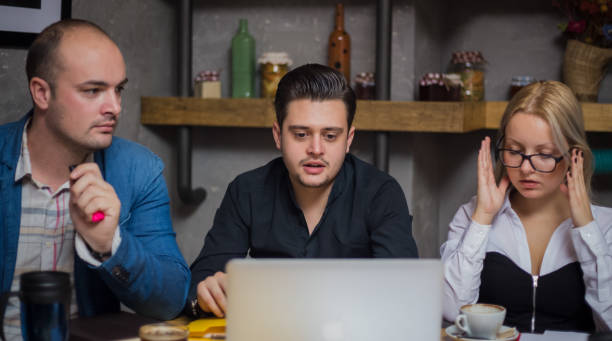 istock Three Businesspeople Working At Laptop In cafe 912751476