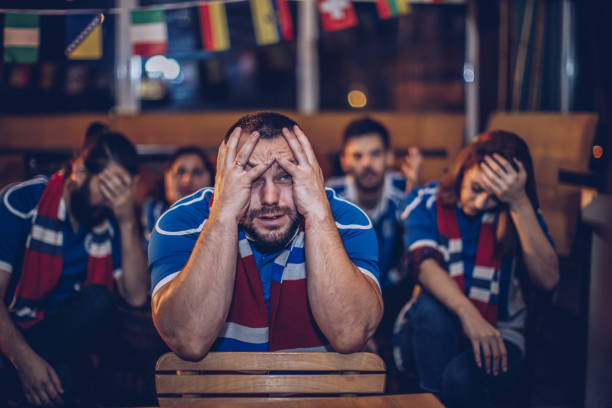 istock Disappointed man watching football game in pub 912752320